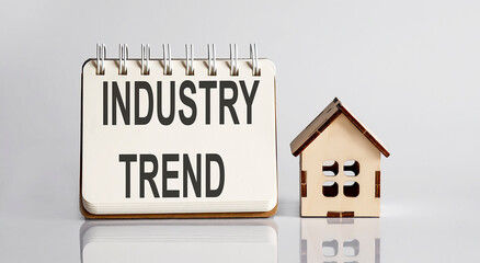 Industry Trends words written in an office notebook with wooden house. Financial Business concept.