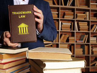  TRADEMARK LAW book in the hands of a jurist. Trademark law governs the use of a device including a word, phrase, symbol, product shape, or logo