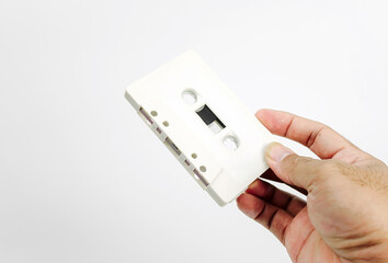 Hand holding cassette tape isolated on white background. Old cassette tape audio isolated on white.	