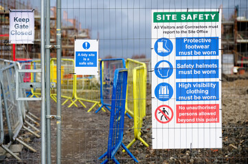 Construction site health and safety message rules sign board signage on fence boundary
