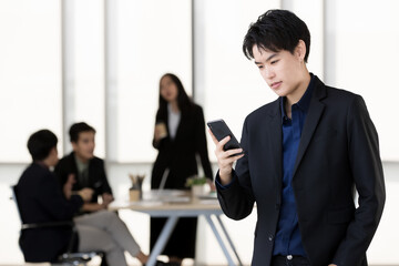 An executive look tomboy woman in casual suit standing with a self-confident and using smartphone...
