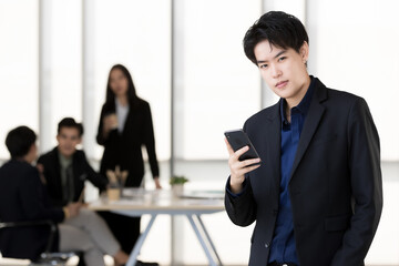 An executive look tomboy woman in casual suit standing with a self-confident and using smartphone...