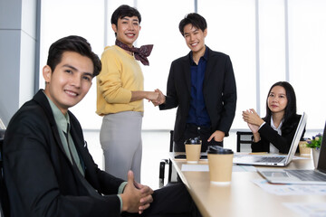 A group of multi sex colleagues, tomboy, transgender and lesbian businesspeople working together with happy and intimate manner. The sissy gay presenting work with cheerful and funny