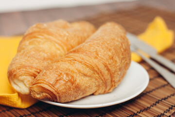 croissants saucer on the table fork with a knife fresh pastries dessert morning