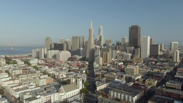 Aerial moving forward to downtown and Transamerica building over Telegraph Hill neighborhood on a clear sunny day - San Francisco, California