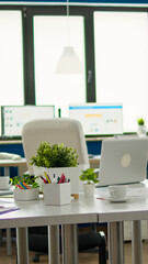 Interior of cozy light company room with conference table ready for brainstorming, modern stylish chairs and desktop monitor, all ready for employees. Empty spacious office of creative working space.