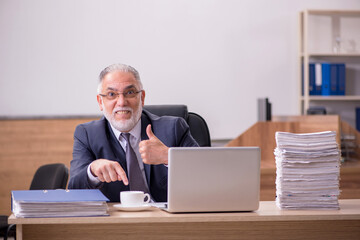 Old male employee drinking coffee during break