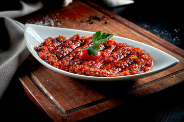 A spicy Turkish appetizer ezme made with tomatoes, bell pepper, parsley, mint, olive oil and hot chili. A kind of adjika