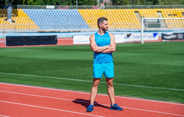 confident fitness trainer standing on stadium, sport