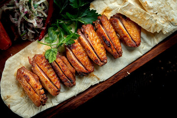 BBQ chicken wings garnished with bulgur, grilled vegetables and pickled onions. Chicken wings shashlik