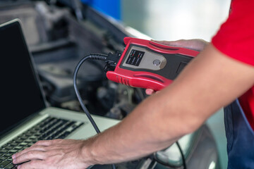 Male hands conducting car diagnostics using computer
