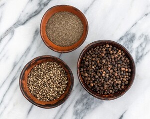 Organic dried Black Peppercorns and peppers are coarse and fine ground in a clay bowls on a marble background close-up. Seasonings and spices.  Selective Focus