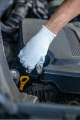 Fototapeta premium Hand twisting under the hood of car