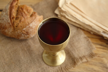 Chalice of wine with bread on table