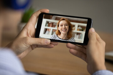 Close up of woman look at cellphone screen watch online webinar on modern gadget. Female talk speak on video call with colleague or client, engaged in webcam virtual conversation. Technology concept.