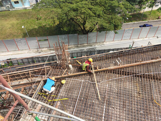 KUALA LUMPUR, MALAYSIA -MARCH 21, 2020: Building floor slab under construction. Construction workers fabricating the timber formwork and installing the steel reinforcement bar. 