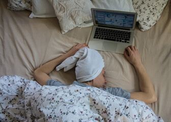 Woman in bed with laptop using internet in online service