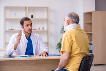 Obraz premium Old neck injured man visiting young male doctor