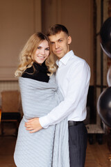 A young man and a woman embrace in a loft-style interior