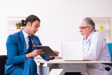 Young businessman meeting with old doctor