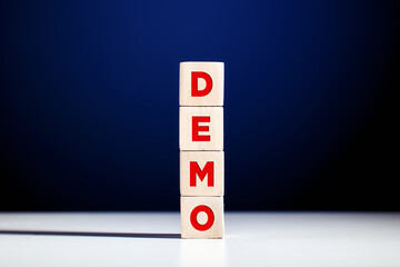 The word demo written on tiered wooden cubes against blue background.