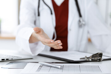 Unknown woman-doctor offering helping hand, close-up. Friendly and cheerful gesture