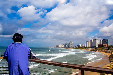 woman in blue dress shirt sees Tel Aviv view on a cloudy day