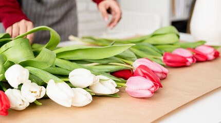 Obraz na płótnie Canvas Woman florist making a bouquet of fresh colorful tulips