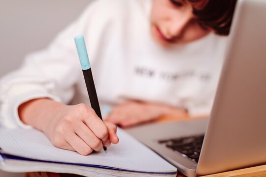 Ni&ntilde;a haciendo deberes con un ordenador port&aacute;til