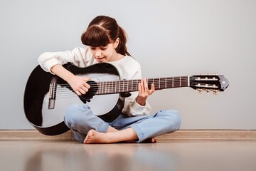 Niña tomando clases de guitarra online por la tablet