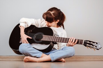 Niña tomando clases de guitarra online por la tablet
