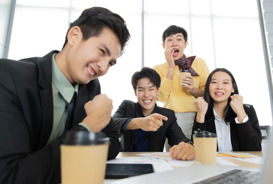 A group of multi-sex colleagues businesspeople working together with happy and intimate manner looking to laptop notebook computer screen with cheerful and excited for good news and success