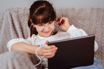 Niña viendo la tablet y escuchando música 