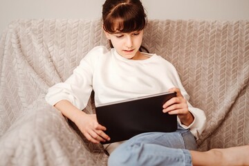 Niña viendo la tablet y escuchando música 