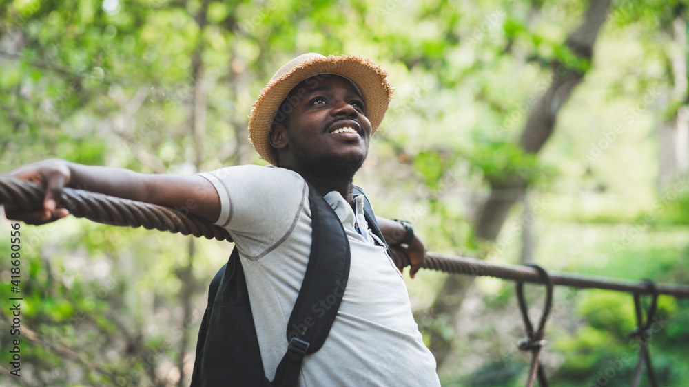 Wall mural African man traveler standing on the bridge with smile and happy.16:9 style