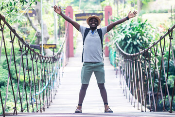 African man traveler standing on the bridge with smile and happy