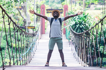 African man traveler standing on the bridge with smile and happy