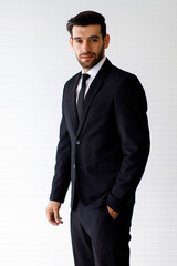 Image is a portrait. Happy and smiling businessman standing smart with black suit In the studio with a white background.