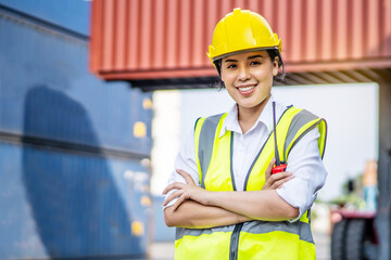 Portrait of asian female engineer wearing protection standing confidently crossed her arms in the cargo area of ​​the ship yard