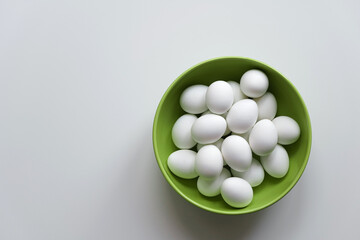 Green bowl of eggs on white background. Healthy food eating or Easter concept. Copy space. Only white