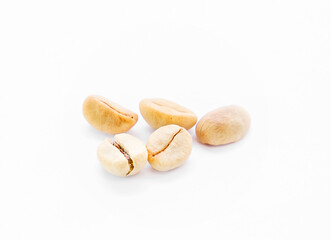 Several unroasted coffee beans on white background