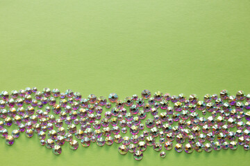 rhinestones on a green background, top photo. design for text