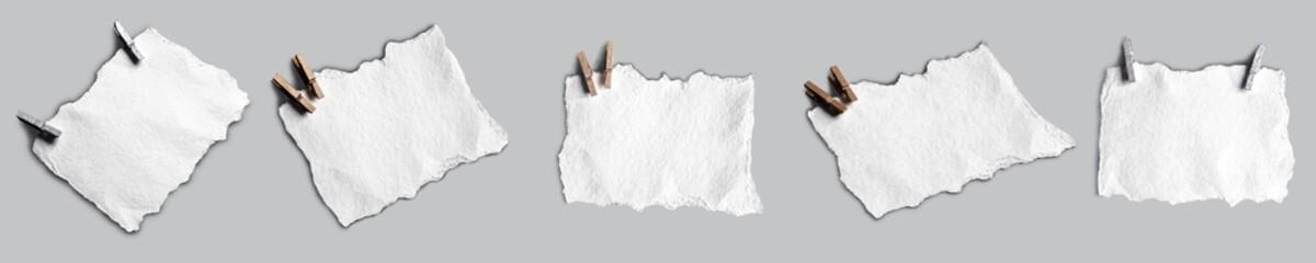 A set of watercolor paper with a ragged edge and clothespins in different orientations