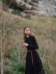 Woman in the forest in a black dress red hair fresh air nature