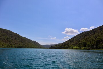 Blick auf einen wunderschönen See umgeben von einer grünen Berglandschaft in Kroatien