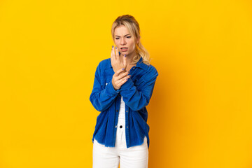 Young Russian woman isolated on yellow background suffering from pain in hands