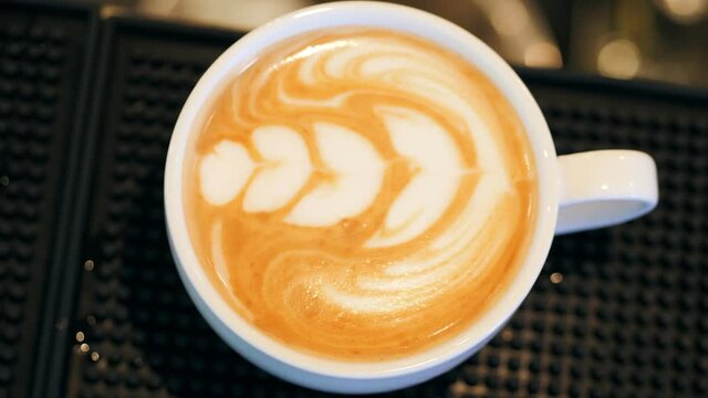 Hand of barista making latte or cappuccino coffee pouring milk making latte art