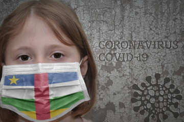 Little girl in medical mask with flag of central african republic stands near the old vintage wall with text coronavirus, covid, and virus picture.