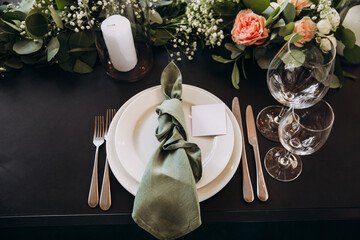 Wedding banquet. The festive table is served with plates with napkins and name cards, glasses and...