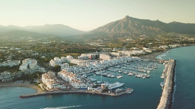 4K aerial perspective of luxury Puerto Banus Bay, in exclusive area of Marbella. Famous location for expensive lifestyle , luxury yacht, exclusive brands shopping area. Drone forward close yachts